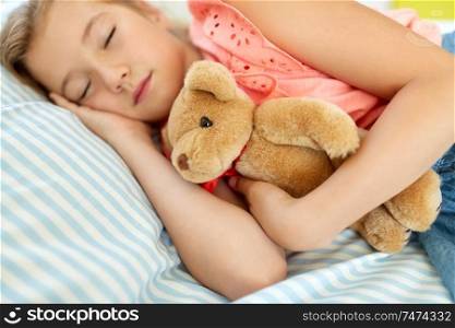 people, childhood and rest concept - little girl sleeping during day with teddy bear toy in her room at home. little girl sleeping with teddy bear toy at home