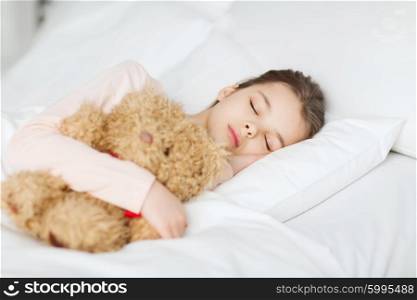 people, childhood, rest and comfort concept - girl sleeping with teddy bear toy in bed at home