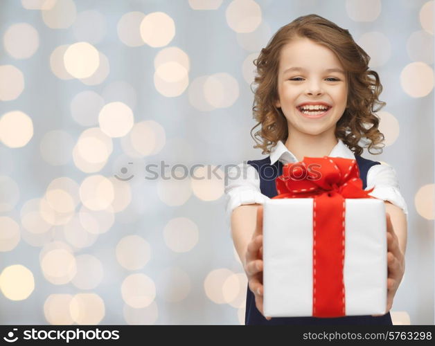 people, childhood, summer and holidays concept - happy smiling girl with gift box over lights background