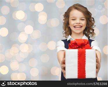 people, childhood, summer and holidays concept - happy smiling girl with gift box over lights background