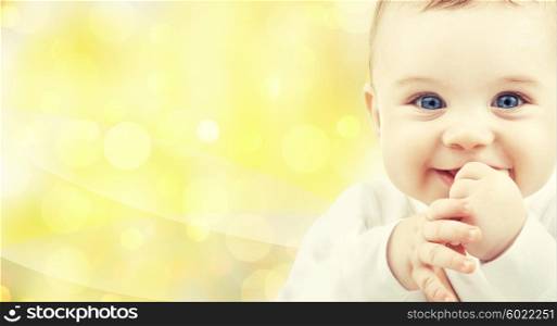 people, children and babyhood concept - close up of of happy baby over yellow background