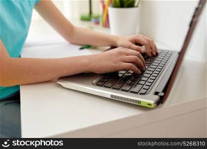 people, children and technology concept - girl hands typing on laptop computer at home. girl typing on laptop at home