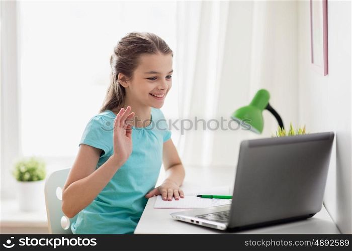 people, children and technology concept - girl with laptop computer having video call at home