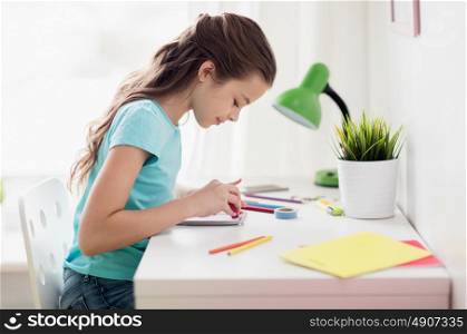people, children, creativity and art concept - happy girl drawing at home. happy girl drawing at home