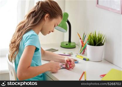 people, children, creativity and art concept - happy girl making something at home. happy girl making something at home