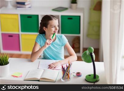 people, children, education and learning concept - happy girl with book and notebook looking through window at home. happy girl with book writing to notebook at home