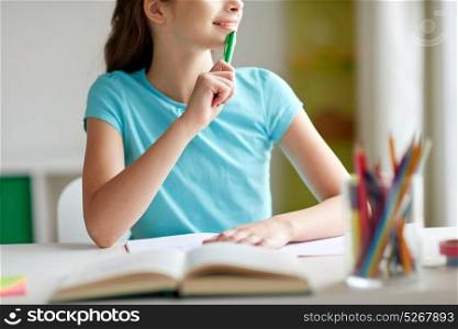 people, children, education and learning concept - happy girl with book and notebook looking to window at home. happy girl with book and notebook dreaming at home