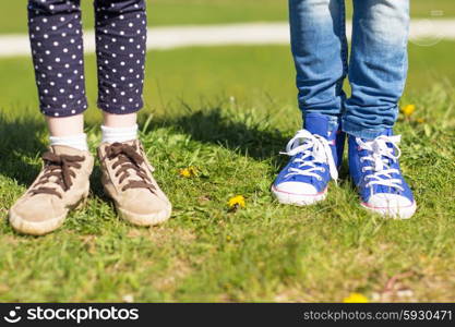 people, children, friends and friendship concept - close up of kids legs in shoes on grass outdoors