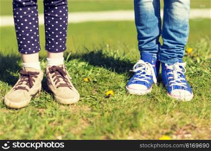 people, children, friends and friendship concept - close up of kids legs in shoes on grass outdoors