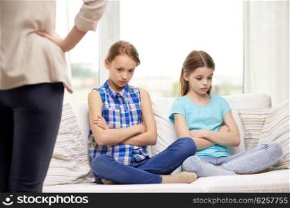 people, children, misbehavior, friends and friendship concept - upset feeling guilty or displeased little girls sitting on sofa and angry mother at home