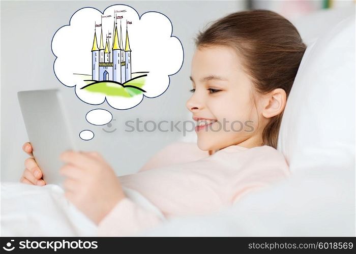 people, children, rest and technology concept - happy smiling girl lying awake with tablet pc computer in bed at home with doodle of fairy castle in cloud
