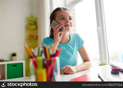 people, children, technology and communication concept - smiling girl calling on smartphone at home. girl calling on smartphone at home