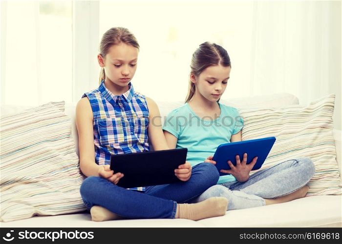 people, children, technology, friends and friendship concept - girls looking to tablet pc computers at home