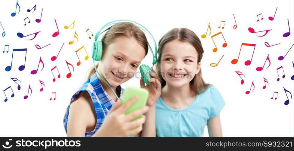 people, children, technology, friends and friendship concept - happy little girls with smartphone and earphones sitting on sofa and listening to music