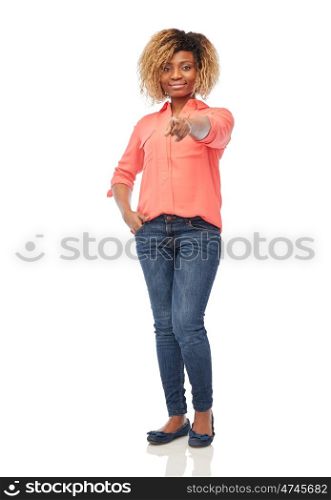 people, choice, ethnicity and gesture concept - happy african american young woman pointing finger at you over white