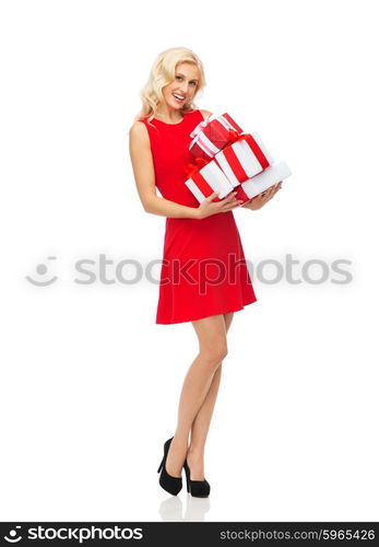 people, christmas, birthday and holidays concept - happy young woman in red dress holding gift boxes