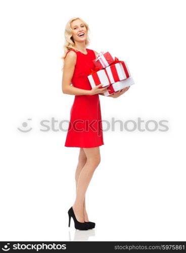 people, christmas, birthday and holidays concept - happy young woman in red dress holding gift boxes