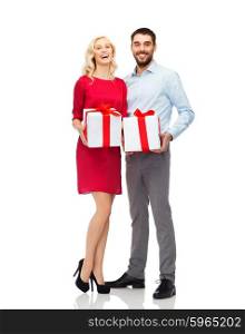 people, christmas, birthday, couple and holidays concept - happy young man and woman with gift boxes