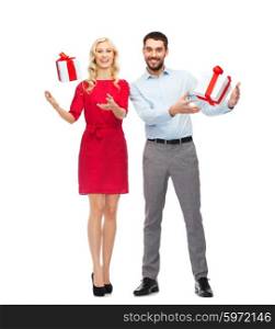 people, christmas, birthday, couple and holidays concept - happy young man and woman with gift boxes