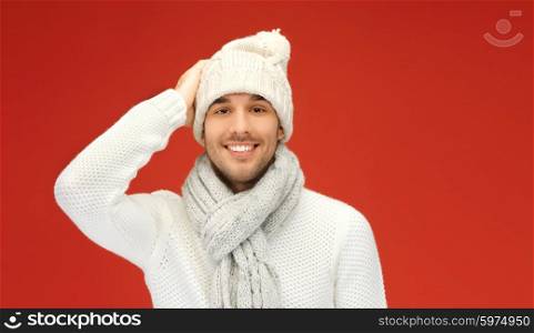 people, christmas, fashion, season and clothing concept - handsome man in winter wear over red background
