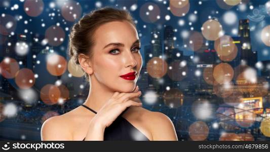 people, christmas, holidays, luxury and fashion concept - beautiful woman in black with red lips over night singapore city lights background and snow
