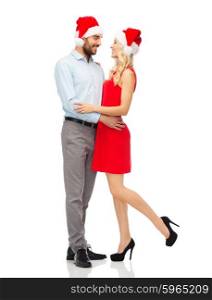 people, christmas, love, couple and holidays concept - happy young woman and man in santa hats hugging