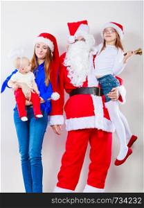People, christmas time household concept. Happy family together with Santa Claus. Portrait of mother, daughters and Christmas Father. . Happy family together with Santa Claus.