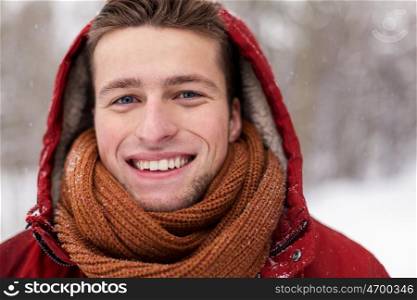people, christmas, winter and season concept - close up of happy smiling man in hood and scarf outdoors