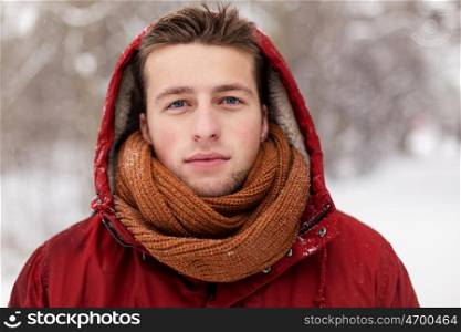 people, christmas, winter and season concept - happy man in hood and scarf outdoors