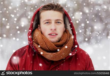 people, christmas, winter and season concept - happy man in hood and scarf outdoors. happy man in winter jacket with hood outdoors