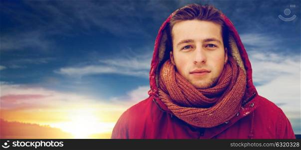 people, christmas, winter and season concept - happy man in hood and scarf outdoors. happy man in winter jacket with hood outdoors