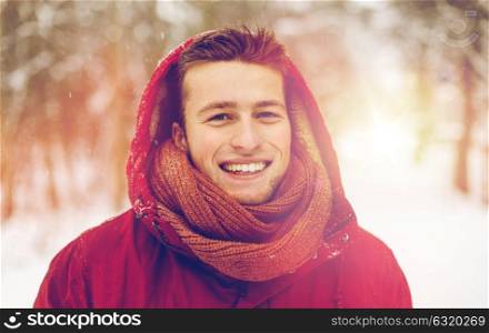 people, christmas, winter and season concept - happy smiling man in hood and scarf outdoors. happy man in winter jacket with hood outdoors