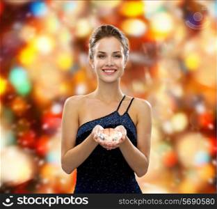 people, christmas, winter holidays and glamour concept - smiling woman in evening dress with diamond over red lights background