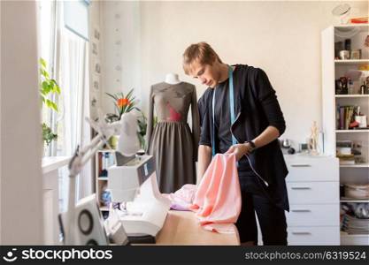 people, clothing and tailoring concept - fashion designer with cloth making new dress at studio. fashion designer with cloth making dress at studio