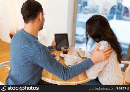 people, communication and dating concept - close up of happy couple with tablet pc computer at cafe or restaurant