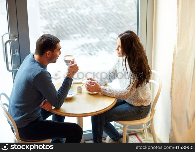 people, communication and dating concept - happy couple drinking tea and coffee at cafe