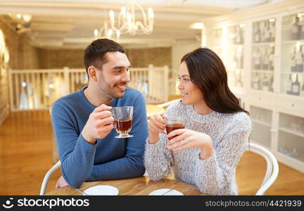 people, communication and dating concept - happy couple drinking tea at cafe or restaurant