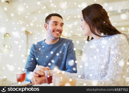 people, communication and dating concept - happy couple drinking tea at cafe or restaurant