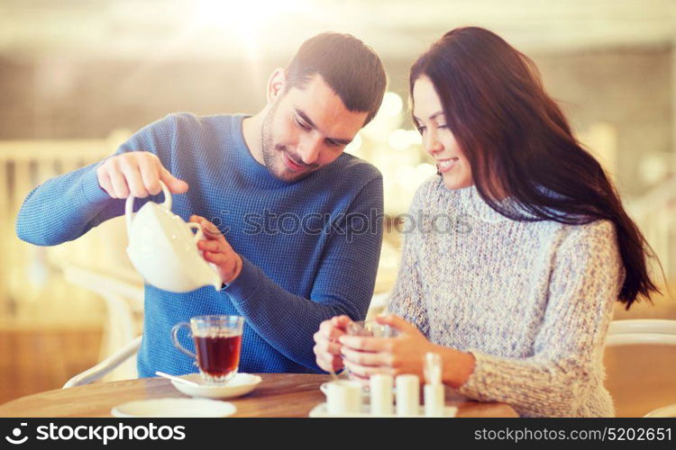 people, communication and dating concept - happy couple drinking tea at cafe or restaurant. happy couple drinking tea at cafe