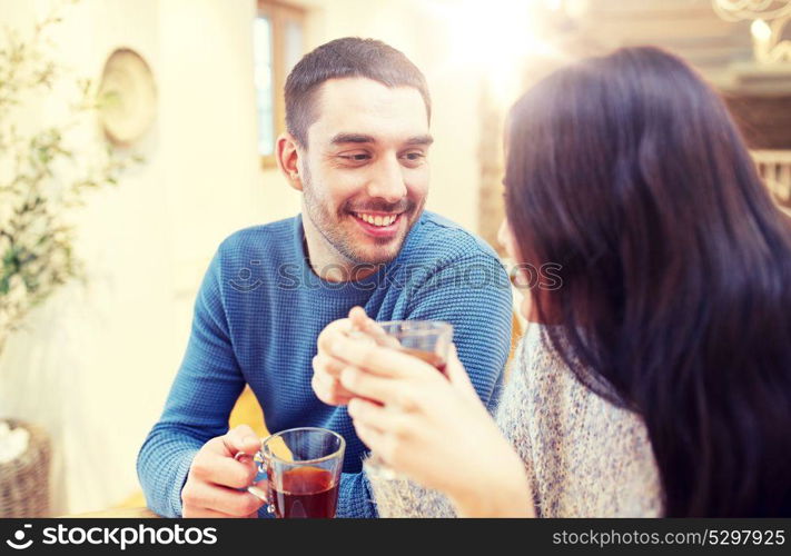 people, communication and dating concept - happy couple drinking tea at cafe or restaurant. happy couple drinking tea at cafe