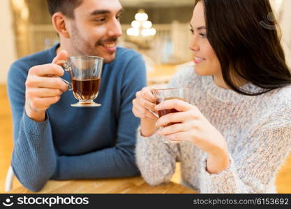 people, communication and dating concept - happy couple drinking tea at cafe or restaurant