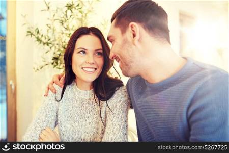people, communication and dating concept - happy couple hugging at cafe or restaurant. happy couple hugging at cafe or restaurant