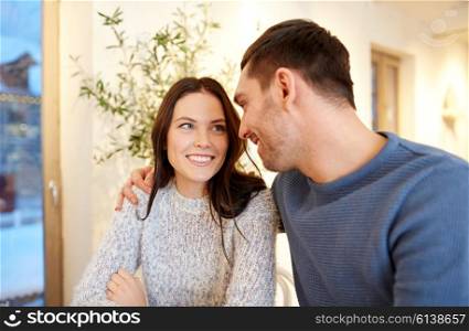 people, communication and dating concept - happy couple hugging at cafe or restaurant