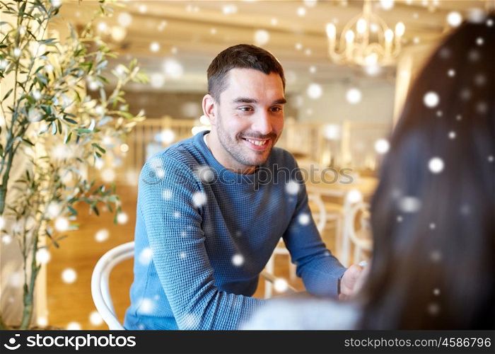 people, communication and dating concept - happy couple talking at cafe or restaurant