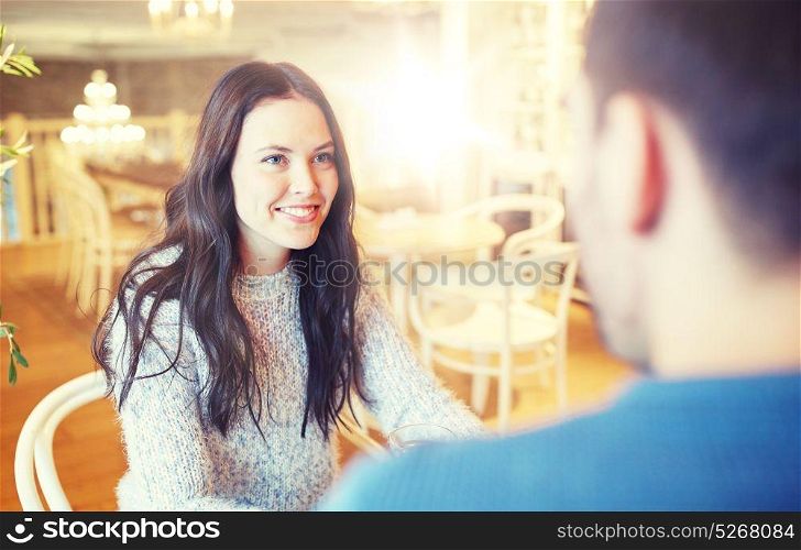 people, communication and dating concept - happy couple talking at cafe or restaurant. happy couple talking at cafe or restaurant
