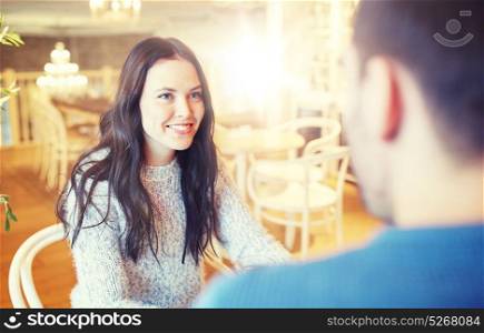 people, communication and dating concept - happy couple talking at cafe or restaurant. happy couple talking at cafe or restaurant