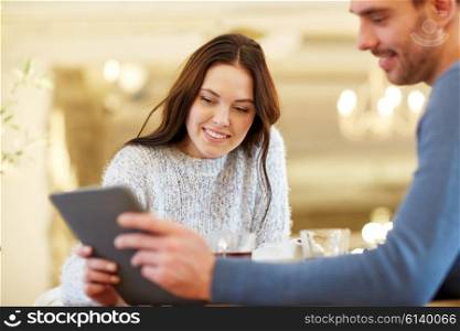 people, communication and dating concept - happy couple with tablet pc computer at cafe or restaurant