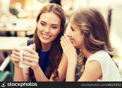 people communication and friendship concept - smiling young women drinking coffee or tea and gossiping at outdoor cafe. young women drinking coffee and talking at cafe