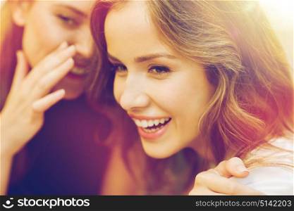 people, communication and friendship concept - smiling young women gossiping and whispering secrets. smiling young women gossiping and whispering