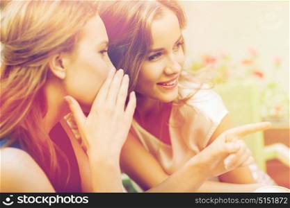 people, communication and friendship concept - smiling young women gossiping at outdoor cafe. smiling young women gossiping at outdoor cafe
